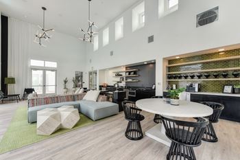 Community Clubhouse with round white table, black chairs, Hardwood Inspired Floor,